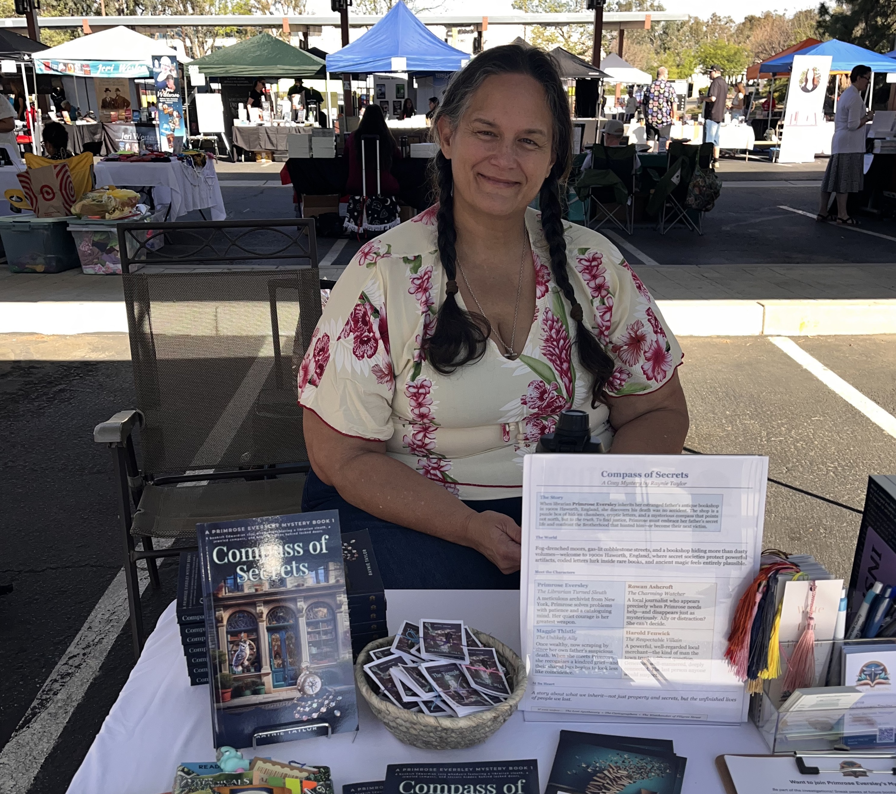 Raynie Taylor sitting at a table featuring her book Compass of Secrets at the Temecula Author Fair